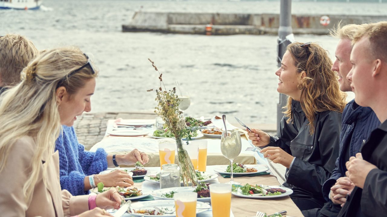 Unge gæster på Kurs Festival nyder middag fra Glad Mad med udsigt til havet