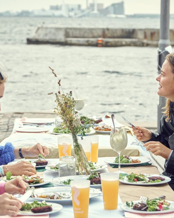 Unge gæster på Kurs Festival nyder middag fra Glad Mad med udsigt til havet